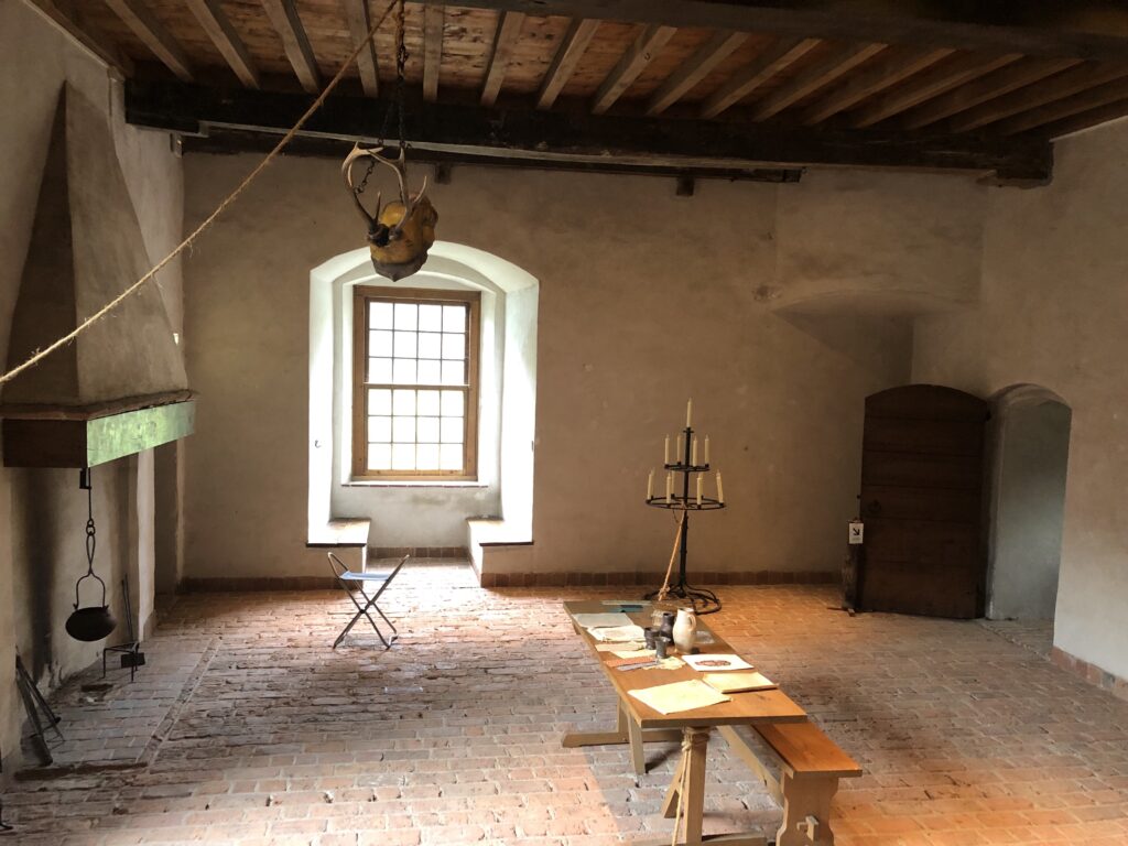 Een kleine zaal met een tafel en diverse museumstukken uit de tijd van de ridders